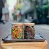 Candied pomelo pith and honey kumquat gift box delivers rich authentic flavors in traditional checkered scarf-wrapped packaging, offering Vietnamese specialty treats as healthy snacks and wellness gifts