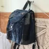 Rugged style mini backpack crafted from old jeans creates street fashion eye-catching impact with convenient drawstring design, serving as sustainable fashion accessory and creative birthday gift