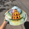 Nón lá cỏ bàng vẽ địa danh Việt Nam thủ công, kèm quai vải chắc chắn, là món quà lưu niệm mang đậm bản sắc Việt.