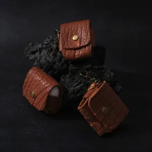 vachetta leather airpod case, natural leather material, protects earphones from scratches, includes brass keychain, elegant design