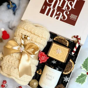 The "A Christmas Carol" Christmas Gift Box, overflowing with Christmas cheer, features a charming music box, a cozy scarf, and a delicate scented candle, all beautifully packaged in a festive paper Christmas gift set