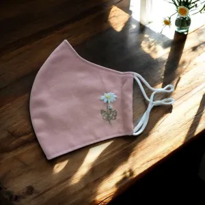 The Wild Daisy Embroidery Linen Face Mask combines elegance and functionality, offering a touch of serenity to each day with its 3-ply design, adjustable straps, and commitment to sustainability as an eco-friendly accessory