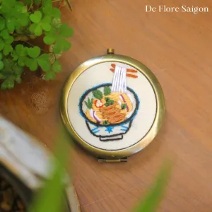 The Hand-Embroidered Mirror, with its captivating design and 25cm diameter, offers a personalized touch, making it a unique handmade accessory and a perfect birthday gift that tells a special tale