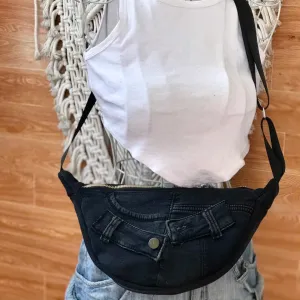 Black half-moon crossbody bag from old jeans adds a touch of mystery in every step, creating an upcycled accessory and unique gift for sustainable fashion enthusiasts