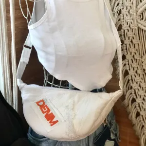 Túi Đeo Chéo Bán Nguyệt Trắng Denim là dấu ấn thời trang tái chế với thiết kế độc bản, chiếc túi vải denim này không chỉ là phụ kiện thời trang bền vững mà còn là món quà sinh nhật cho nữ đầy cá tính và ý nghĩa.