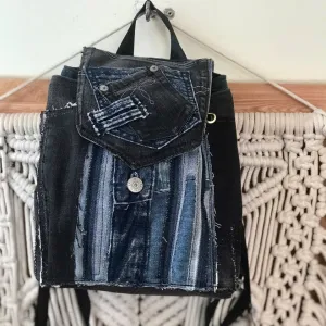 Layered mini backpack crafted from old jeans ignites your personal style through upcycled fabric design, combining rugged fashion aesthetic with environmental consciousness as unique recycled accessory and creative birthday gift