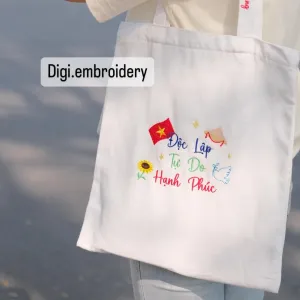Vietnamese national motto embroidered tote bag with personalized name on strap brings Vietnam everywhere you go, featuring convenient zipper closure in a thoughtful personalized gift and meaningful Vietnamese souvenir.