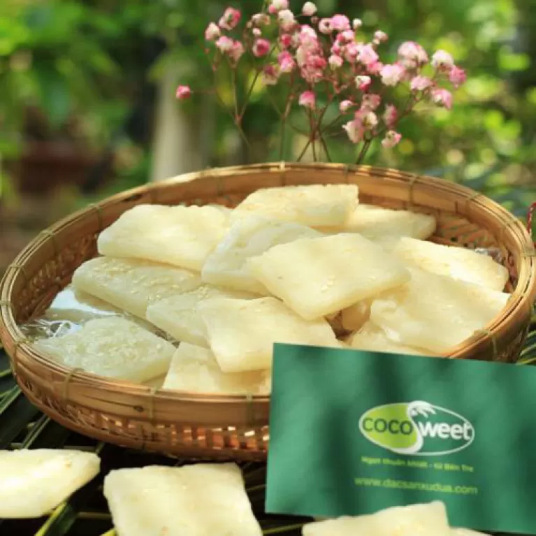 young coconut candy, vietnamese specialty, sweet chewy coconut candy, sprinkled with white sesame seeds, served with tea, gift for friends