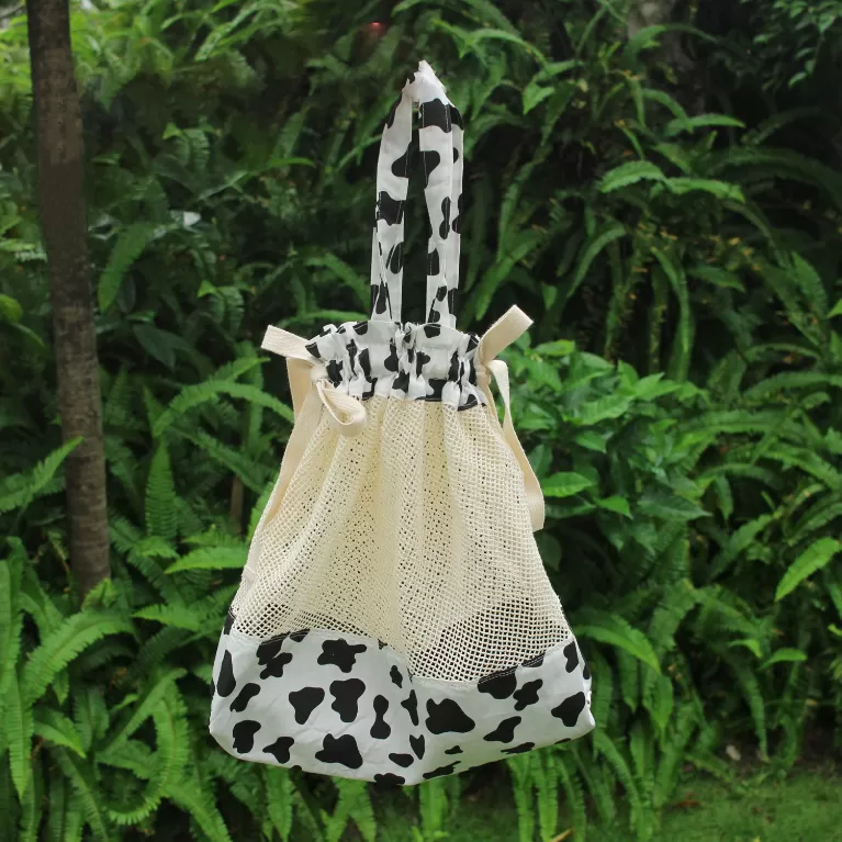 cow pattern shopping bag, breathable mesh design, fun cow print pattern, secure drawstring closure, environmentally friendly solution