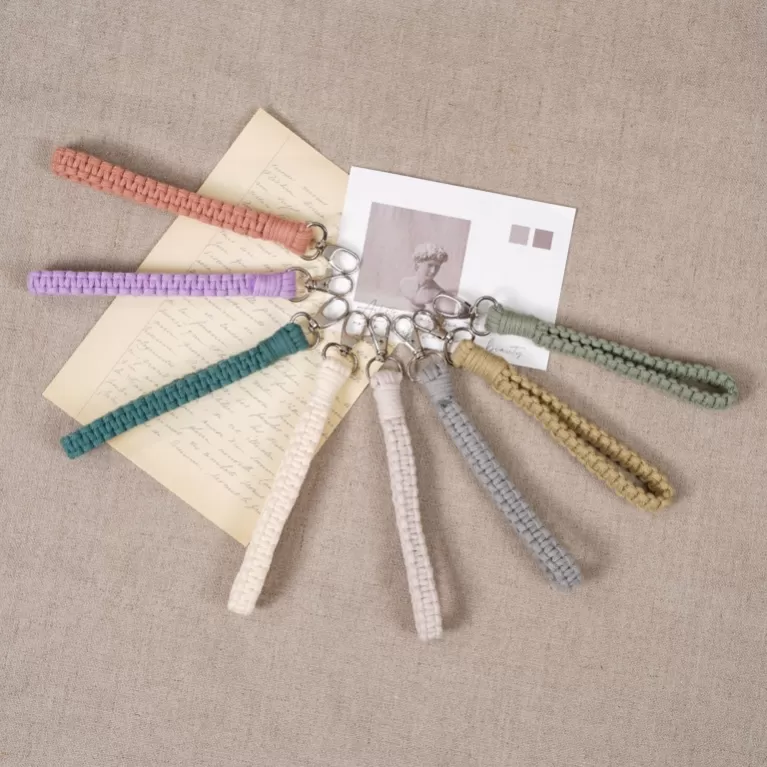 buttercup macrame keychain, pastel colors, minimalist monochrome design, sturdy woven fiber material, can be worn as a wristband