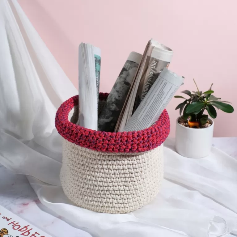 white with red and purple border crochet cotton basket, subtle contrasting colors, elegant style, adds focal point to room corner