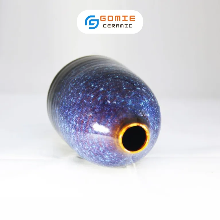 The Ocean Blue Fire-Glazed Ceramic Narrow Mouth Vase, sized 8 x 11cm, adds a distinctive touch to your space as a stunning Bat Trang flower vase, perfect for home decor or as a thoughtful housewarming gift.