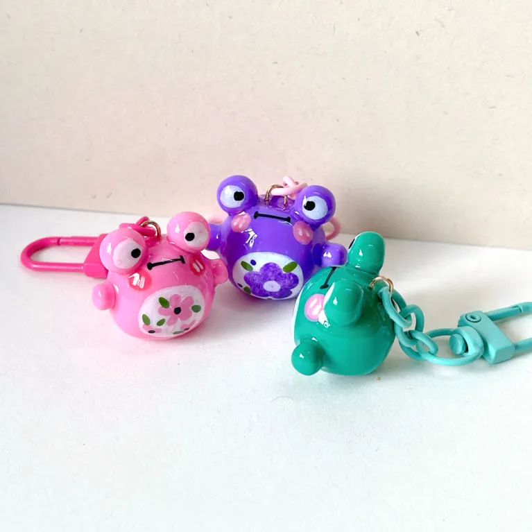 The Handmade Clay Colorful Frog Keychain boasts an adorable and charming look, making it the perfect clay bag charm, unique accessory, and lovely handmade gift, a thoughtful gift for her!