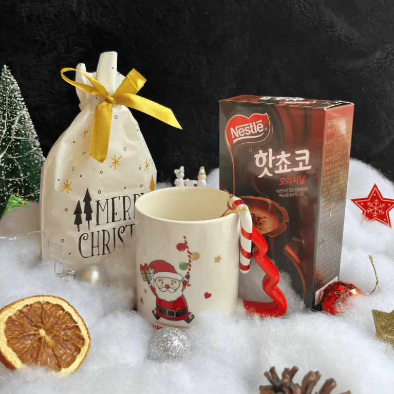 The "A Bag of Joy" Christmas Gift Set, bursting with youthful fun, is a transparent gift basket featuring a ceramic mug, cocoa, and marshmallows, making it a unique Christmas gift perfect for spreading holiday cheer