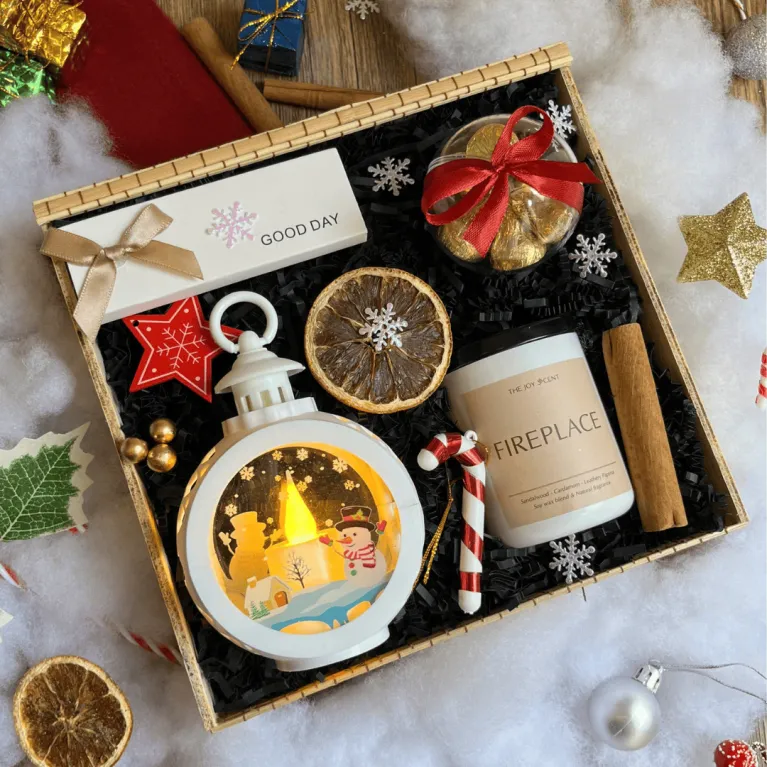 The "Light Up The Night" Christmas Gift Box is the perfect way to warm up the holiday season, featuring a gift set with a scented candle, lamp, and chocolate ornament, making it an ideal corporate gift set to spread festive cheer