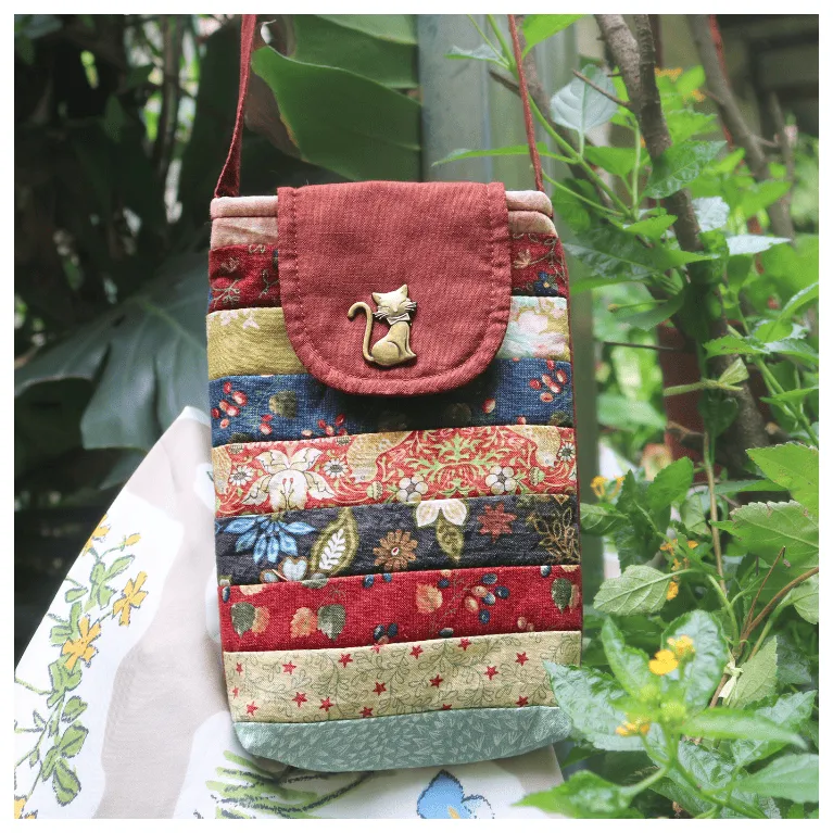 The Magpie Robin Phone Bag, with its vibrant and vintage colors, is a charming handmade patchwork phone pouch, doubling as a mini crossbody bag and making it a perfect vintage handmade accessory and thoughtful gift for her