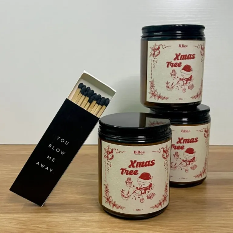 The Xmas Tree Scented Candle Gift Box (220g) is a perfect holiday delight, featuring a natural wax Christmas-scented candle complete with festive stickers and matches, all beautifully packaged to sweeten up your holiday!