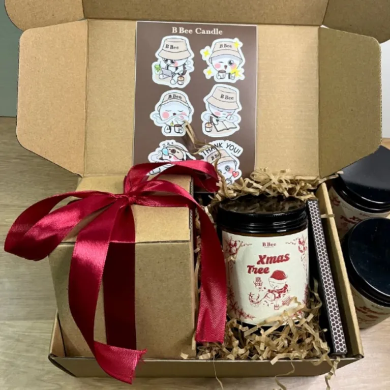 The Xmas Tree Scented Candle Gift Box (220g) is a perfect holiday delight, featuring a natural wax Christmas-scented candle complete with festive stickers and matches, all beautifully packaged to sweeten up your holiday!