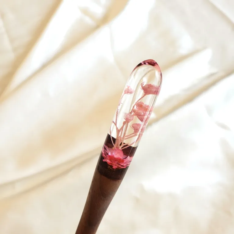 Trâm cài tóc gỗ resin đầu tròn với họa tiết hoa duyên dáng, thiết kế nhẹ nhàng nữ tính, làm từ chất liệu gỗ cứng cáp, là món quà sinh nhật ấn tượng dành cho nữ, mang đậm dấu ấn quà tặng Việt Nam