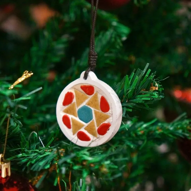 The Christmas Decoration Mosaic Kit offers various designs, including bag charms, handmade accessories, and ceramic mosaics, making it a unique gift for kids and a perfect Christmas tree ornament