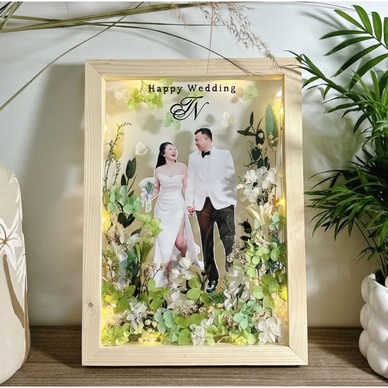 Capture and preserve your cherished moments with a Wooden Framed Dried Flower Art, beautifully customized with your photo and message, creating a heartfelt souvenir and a unique handmade decoration that celebrates life’s precious memories