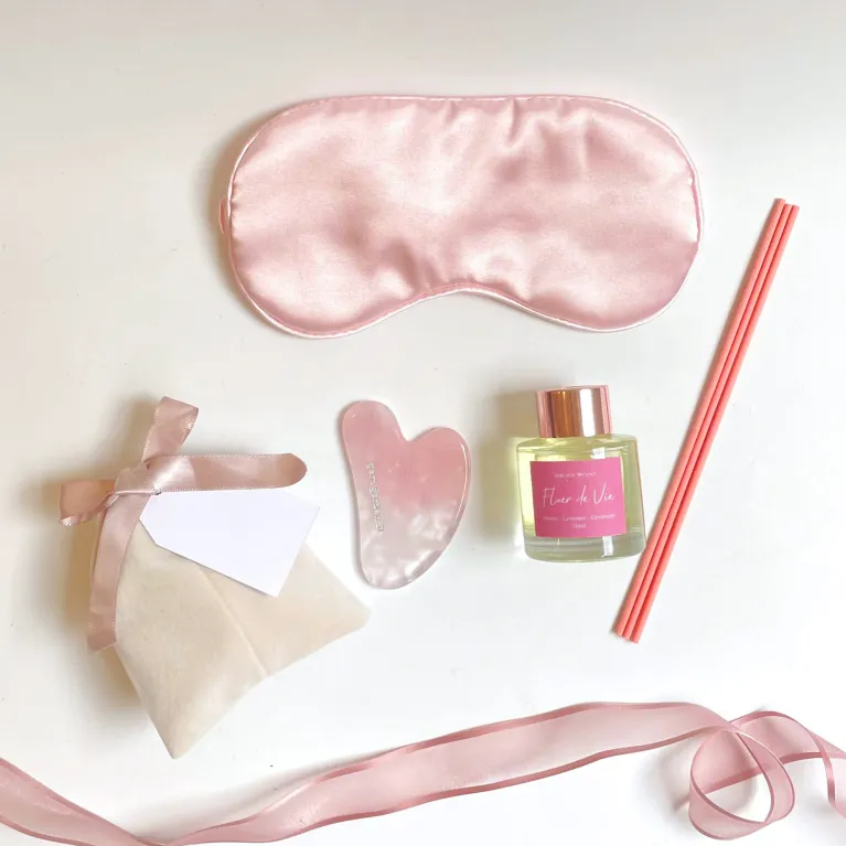 The "Rose Quartz" Gift Box is a romantic Women's Day gift designed to cherish your beloved woman, featuring a luxurious Gua Sha stone, soothing eye mask, essential oil, and a surprise blind bag for an extra touch of love and elegance