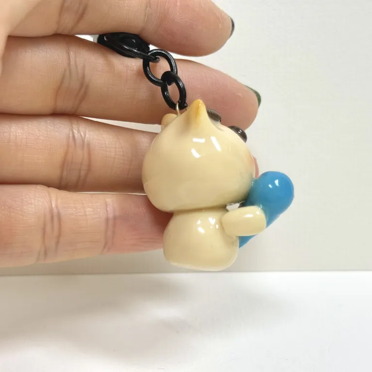 The Handmade Clay Cat Hugging Fish Keychain boasts a charming look that everyone adores, making it a lovely accessory - a handcrafted bag charm and clay keychain that's the perfect cute gift for her