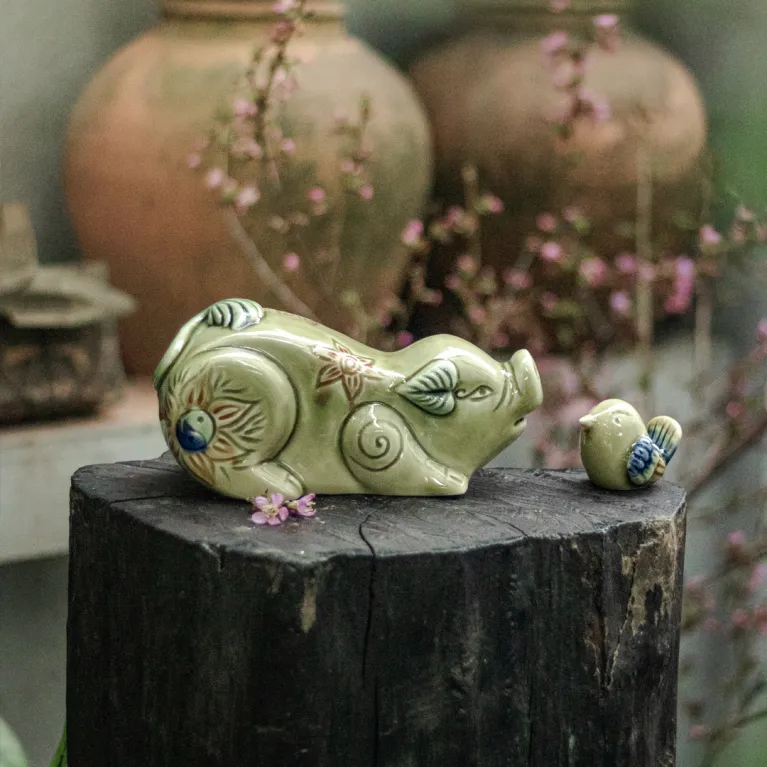 Tượng heo hoan hỉ gốm sứ mang vẻ vui tươi hớn hở đáng yêu, được chế tác từ nghệ thuật gốm truyền thống, vừa là món đồ trang trí nhà cửa tinh tế, vừa là quà lưu niệm đặc trưng của Việt Nam và món quà tặng phong thủy mang lại may mắn.