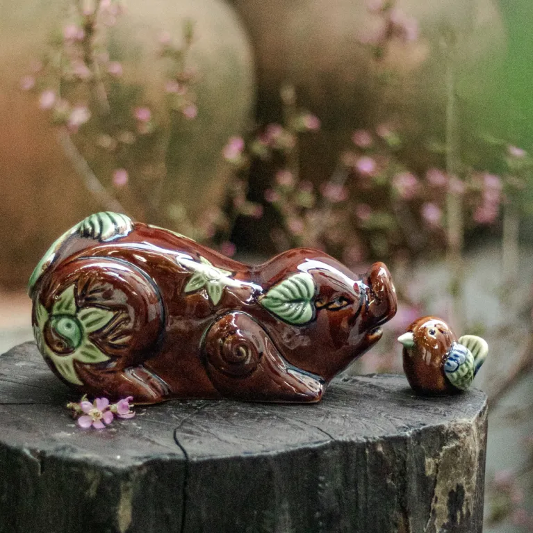 Tượng heo hoan hỉ gốm sứ mang vẻ vui tươi hớn hở đáng yêu, được chế tác từ nghệ thuật gốm truyền thống, vừa là món đồ trang trí nhà cửa tinh tế, vừa là quà lưu niệm đặc trưng của Việt Nam và món quà tặng phong thủy mang lại may mắn.