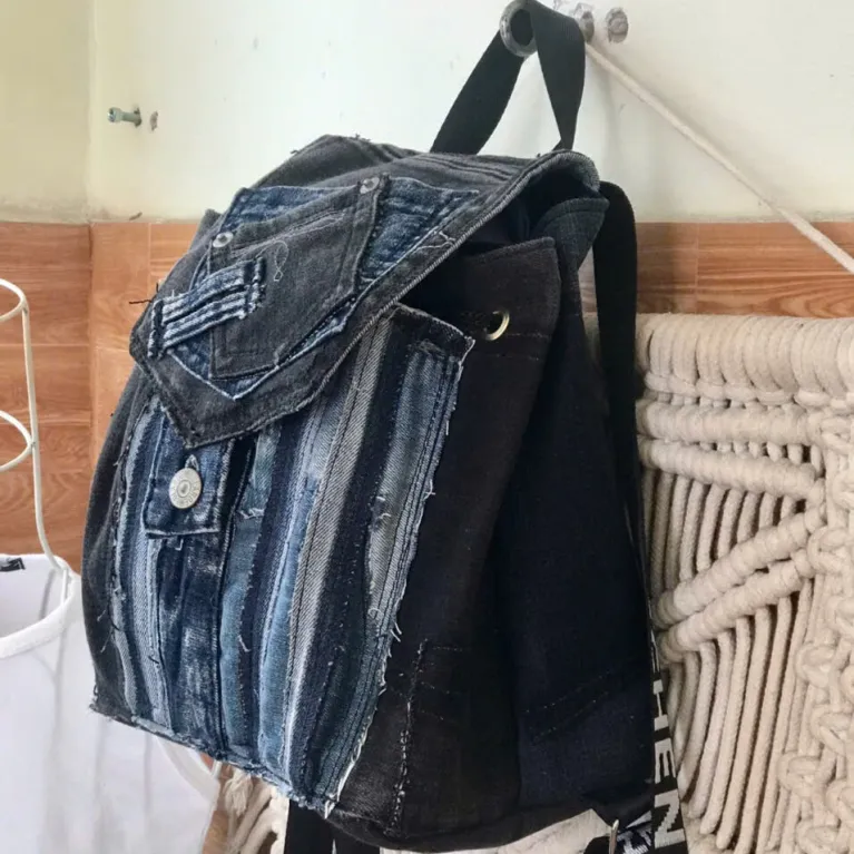 Layered mini backpack crafted from old jeans ignites your personal style through upcycled fabric design, combining rugged fashion aesthetic with environmental consciousness as unique recycled accessory and creative birthday gift