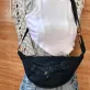 Black half-moon crossbody bag from old jeans adds a touch of mystery in every step, creating an upcycled accessory and unique gift for sustainable fashion enthusiasts