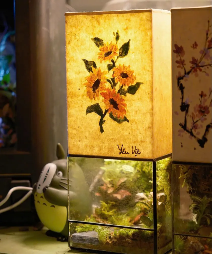 Đèn trang trí "Terra Light" với lọ tiểu cảnh thủy tinh kết hợp ánh sáng ấm áp, mang đến không gian hài hòa giữa cỏ cây và ánh sáng, thích hợp làm quà lưu niệm hay quà sinh nhật. Đèn trang trí "Terra Light" với lọ tiểu cảnh thủy tinh kết hợp ánh sáng ấm áp, mang đến không gian hài hòa giữa cỏ cây và ánh sáng, thích hợp làm quà lưu niệm hay quà sinh nhật.