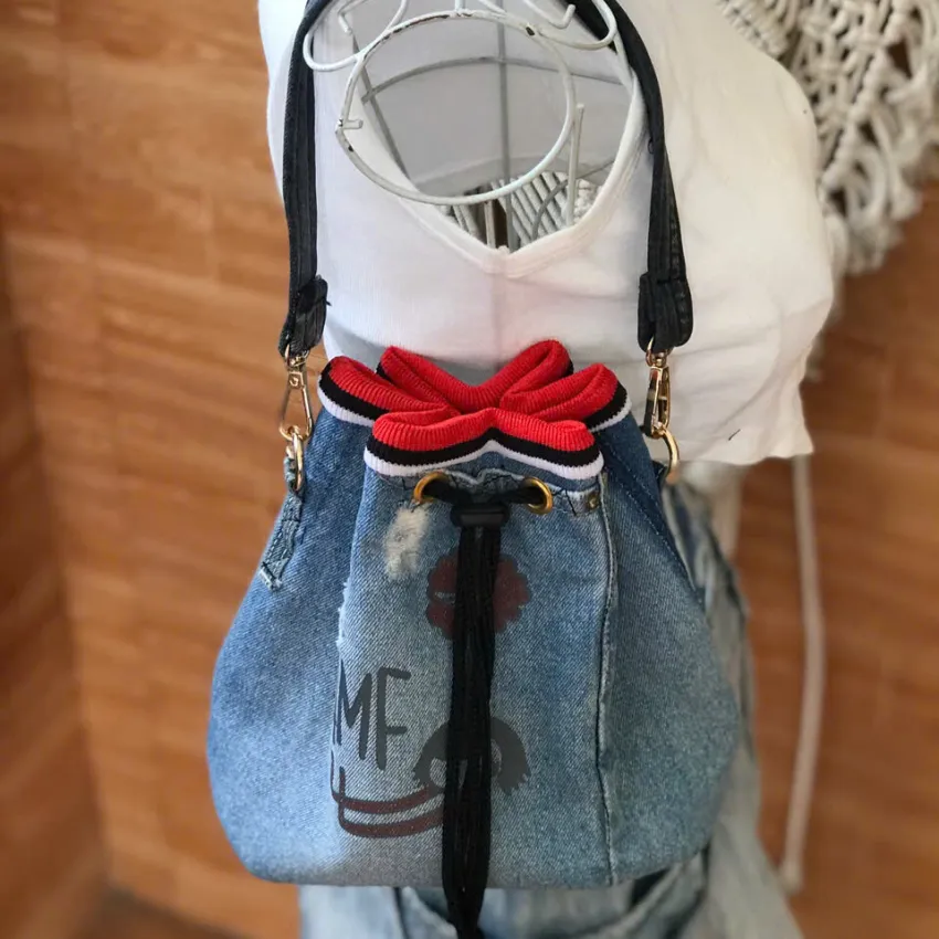 Túi bucket viền đỏ từ jeans tái chế thể hiện sự sáng tạo tự do của thời trang bền vững, túi dây rút vải jeans tái chế làm quà tặng thủ công và quà sinh nhật ý nghĩa Túi bucket viền đỏ từ jeans tái chế thể hiện sự sáng tạo tự do của thời trang bền vững, túi dây rút vải jeans tái chế làm quà tặng thủ công và quà sinh nhật ý nghĩa