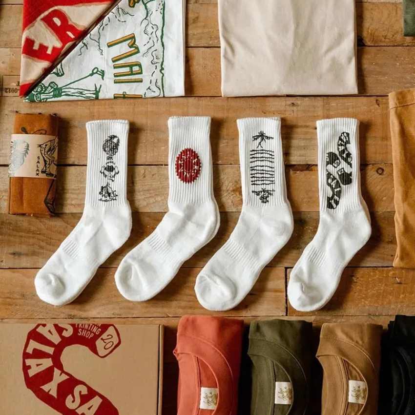 White cotton crew socks with Salaxsaler’s exclusive signature, crafted from soft thick cotton and hand-silkscreened—perfect travel socks, stylish fashion accessory, and unique souvenir.